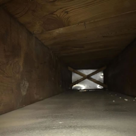 Technician installing a whole-house air cleaner in a New York HVAC return